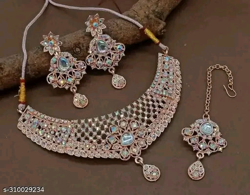 Jewelry set with necklace, earrings, and hair accessory on a brown background